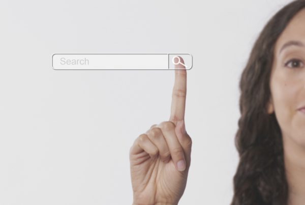 Na obrázku je žena, která ukazuje prstem na internetový vyhledávač